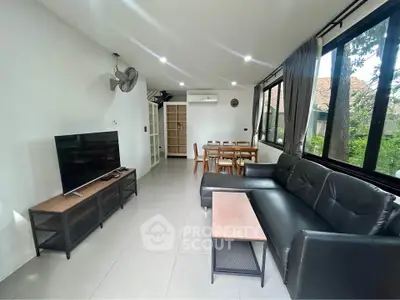 Spacious living room with modern furniture and large windows offering natural light.