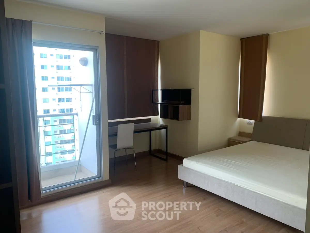 Modern studio apartment with balcony and workspace in urban setting