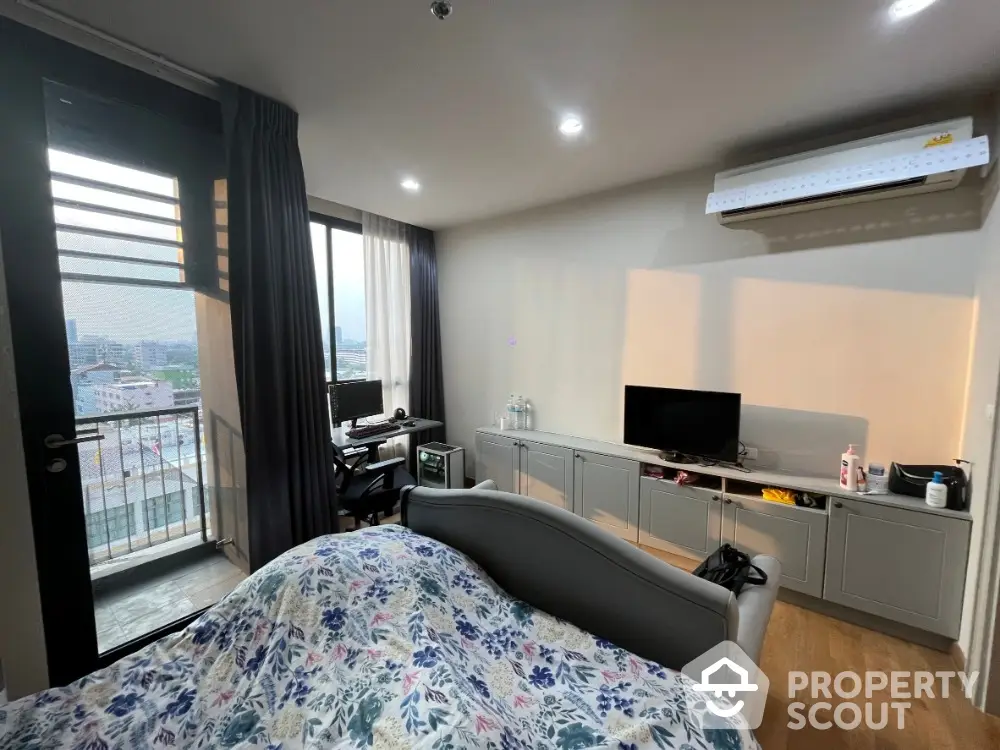 Modern bedroom with balcony and city view, featuring air conditioning and stylish decor.