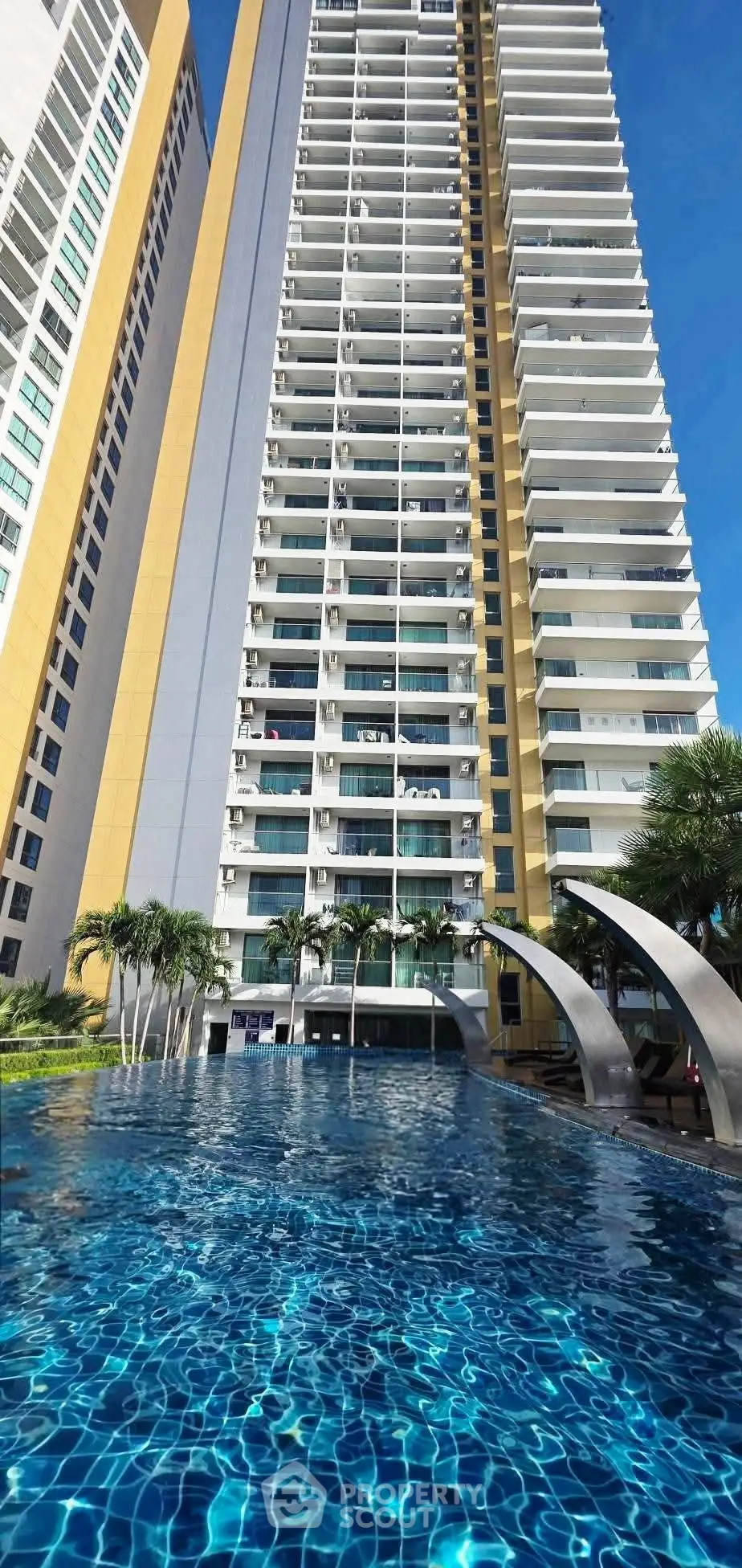 Stunning high-rise building with luxurious pool and modern architecture.
