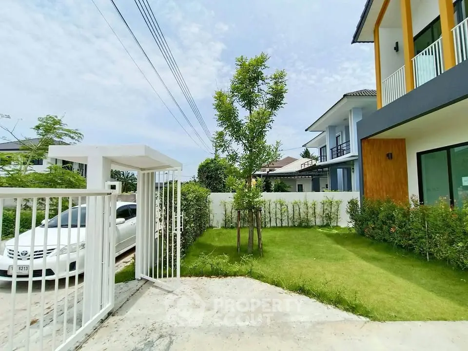 Modern house exterior with lush green lawn and gated entrance in a serene neighborhood.