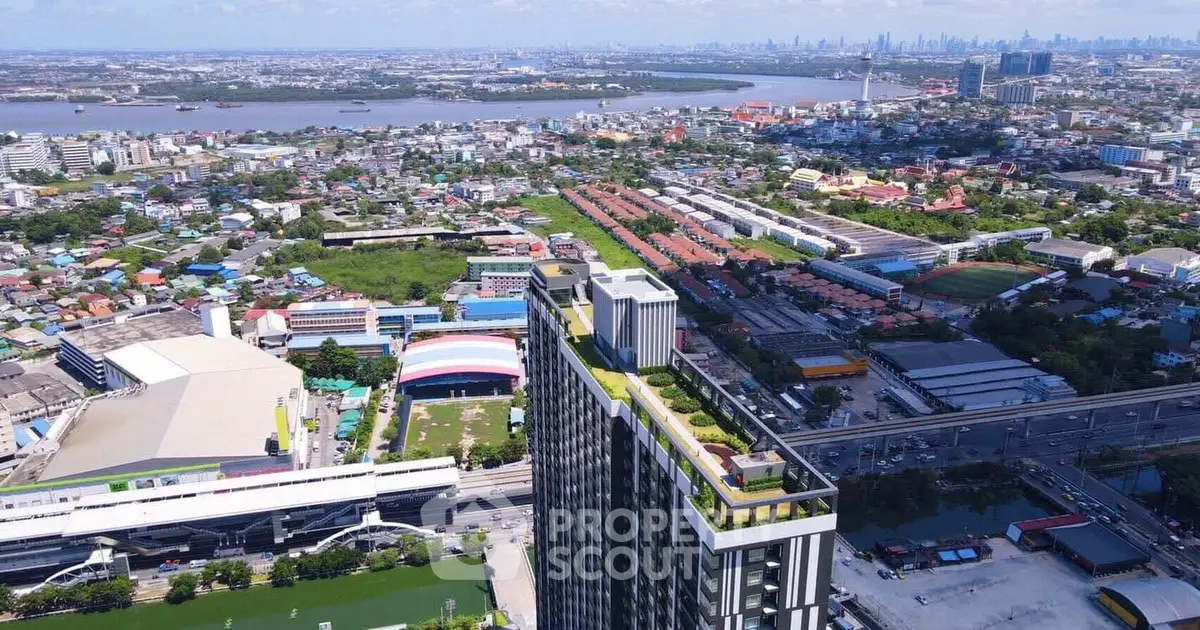 Stunning aerial view of modern high-rise building with lush rooftop garden and panoramic cityscape.