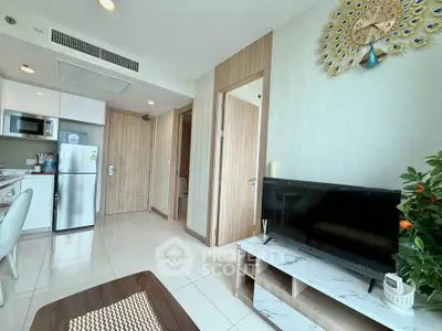 Modern living room with stylish decor and open kitchen layout, featuring a sleek TV unit and contemporary appliances.
