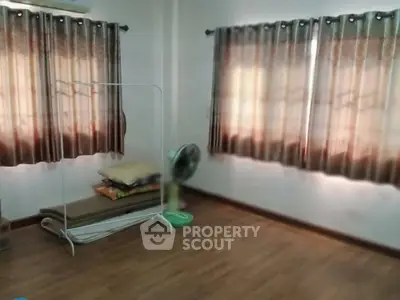 Spacious empty room with wooden flooring and large windows, ideal for customization.