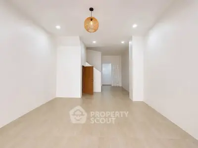 Spacious minimalist interior with modern lighting and open layout, perfect for versatile living arrangements.