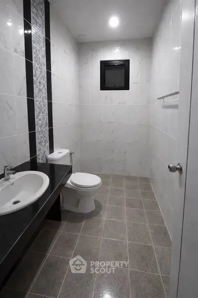 Modern bathroom with sleek design and elegant tile work, featuring a spacious layout and contemporary fixtures.