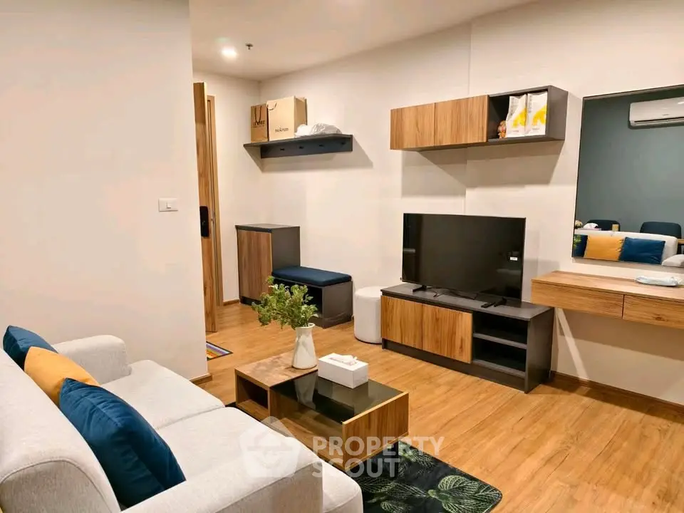 Modern living room with stylish furniture and wooden flooring, featuring a cozy ambiance and sleek TV setup.