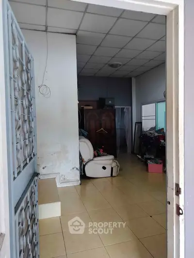Spacious room with tiled floor and high ceiling, ideal for storage or creative workspace.