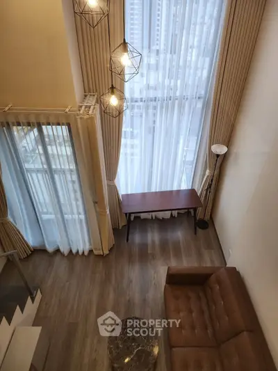 Stunning high-ceiling living room with modern decor and large windows offering city views.