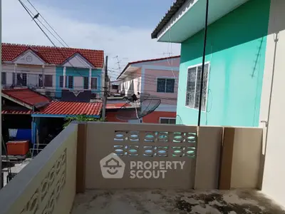 Charming balcony view in a vibrant neighborhood with colorful houses and clear sky.