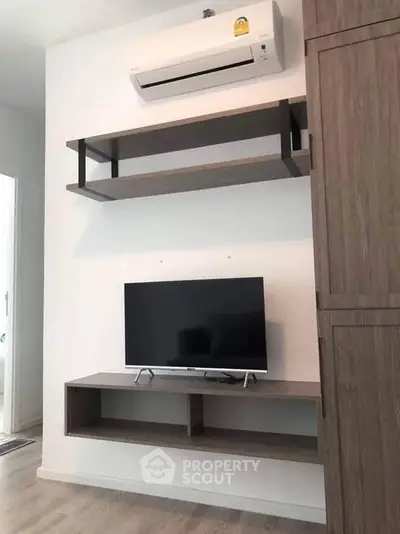 Modern living room with wall-mounted TV and air conditioning unit
