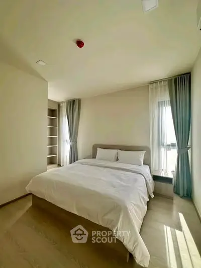 Spacious bedroom with natural light and modern decor in a stylish apartment.