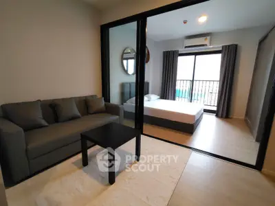 Modern apartment with cozy living room and spacious bedroom featuring balcony view.