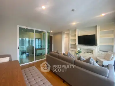 Spacious living room with modern decor and large TV, perfect for relaxation.