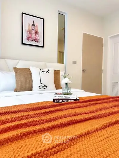 Cozy bedroom with modern decor and vibrant orange blanket