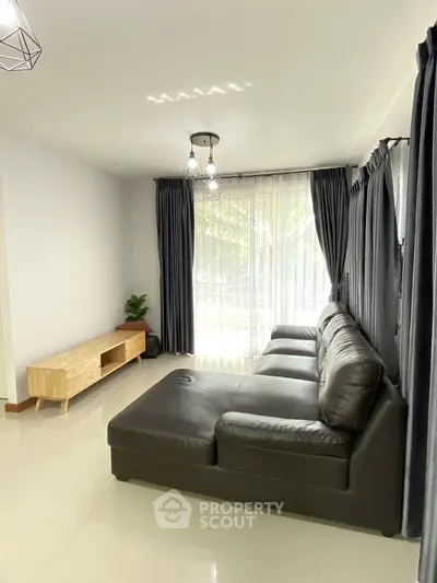 Spacious living room with modern leather sofa and natural light