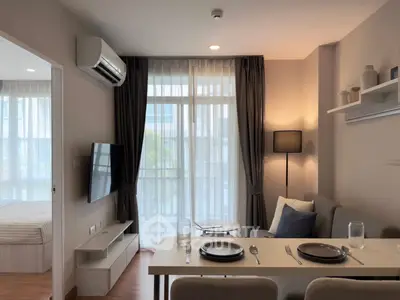 Modern living room with dining area and balcony view in a stylish apartment.