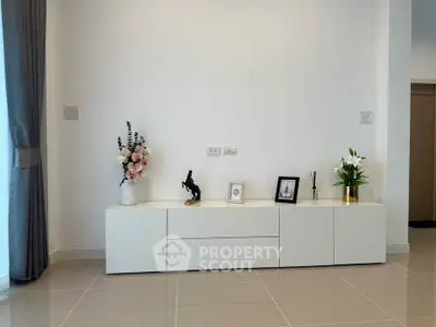 Modern minimalist living room with sleek white cabinet and elegant decor.