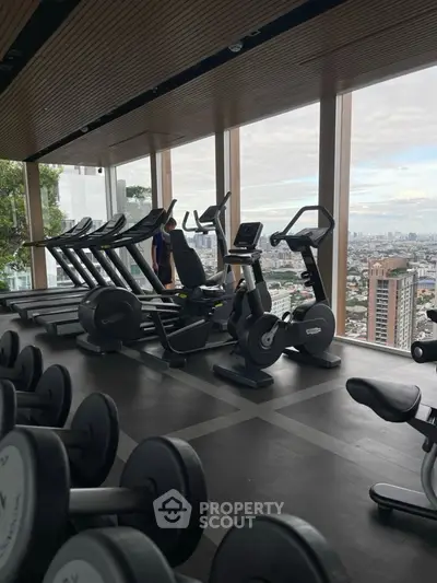 Modern high-rise gym with panoramic city views and state-of-the-art fitness equipment.