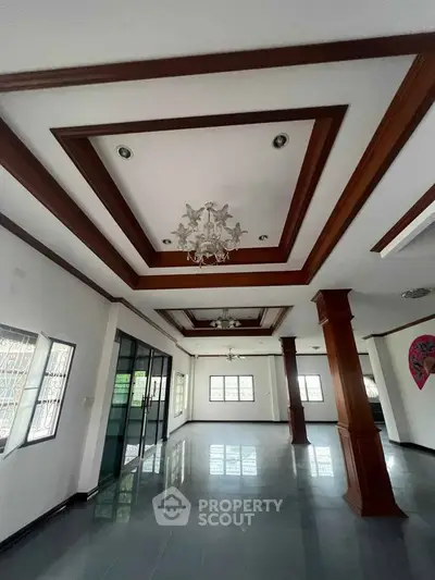 Spacious living room with elegant ceiling design and large windows for natural light.