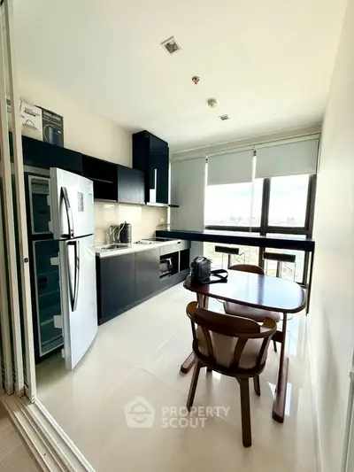 Modern kitchen with sleek black cabinets, dining table, and city view from large window.
