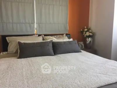 Cozy bedroom with stylish decor and plush bedding in modern apartment.
