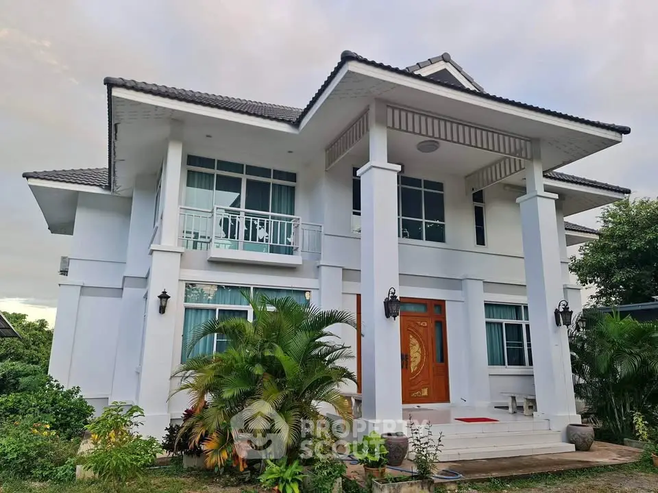 Stunning two-story white house with lush greenery and elegant entrance