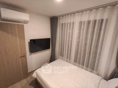 Cozy bedroom with modern decor and wall-mounted TV, featuring soft lighting and elegant curtains.