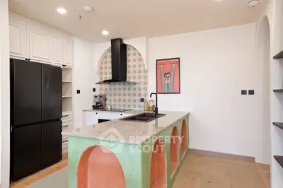 Stylish kitchen with unique island and modern appliances in a contemporary home.