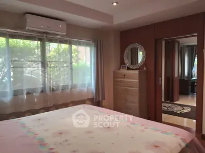 Cozy bedroom with large window and air conditioning, featuring elegant decor and ample natural light.