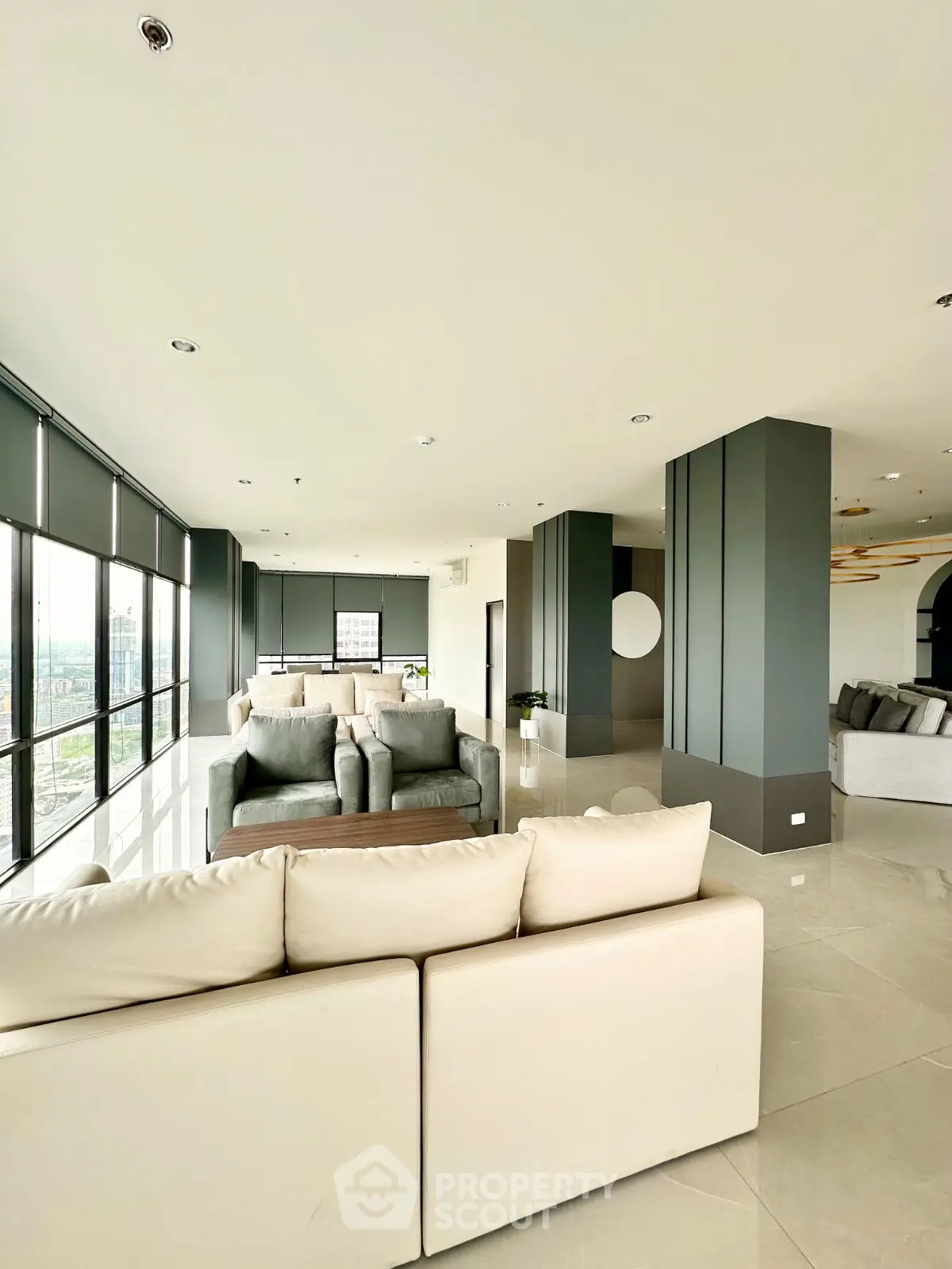 Spacious modern living room with panoramic city views and elegant furnishings.