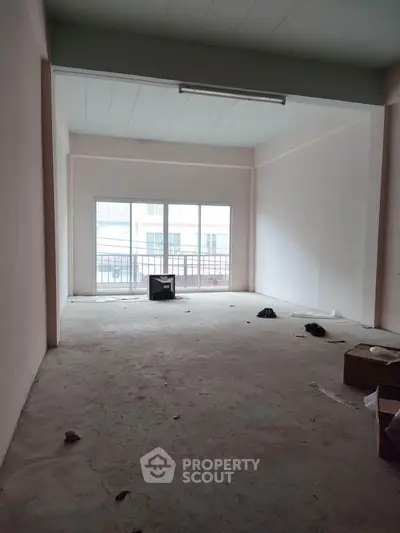 Spacious unfinished room with large window and balcony view, ideal for customization.
