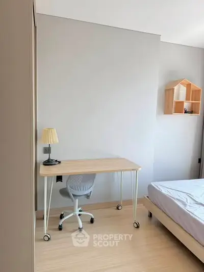 Modern minimalist bedroom with study desk and chair, perfect for a cozy and functional living space.