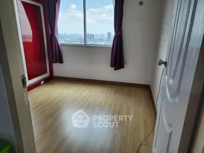 Spacious bedroom with city view and wooden flooring, ideal for urban living.