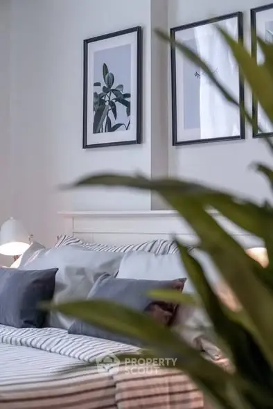 Cozy bedroom with stylish decor and framed art on the wall.
