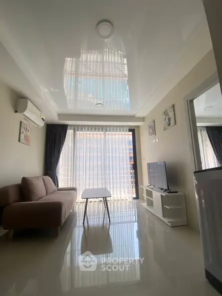 Modern living room with sleek furniture and large windows offering natural light.