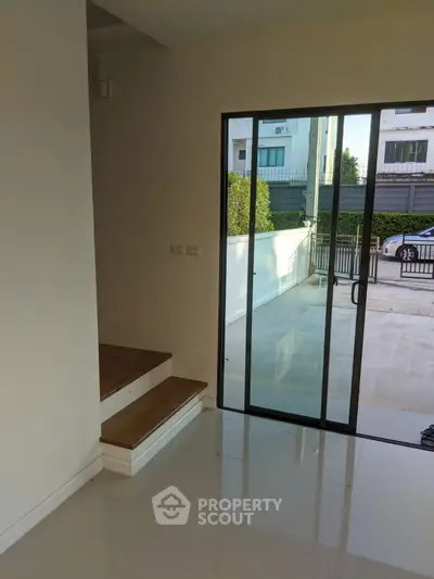 Modern home entrance with sliding glass door and wooden steps