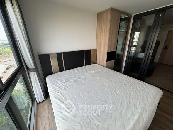 Modern bedroom with large windows and stylish wardrobe in a contemporary apartment.
