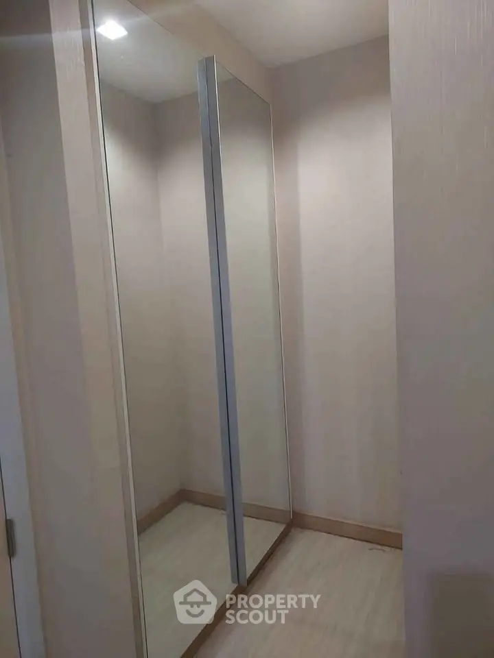 Spacious walk-in closet with full-length mirrors and modern design.