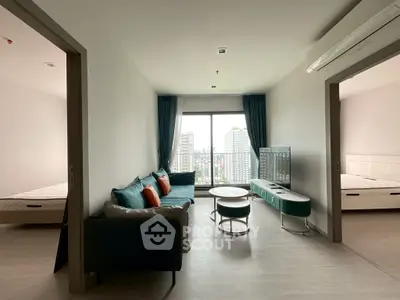 Modern living room with city view, stylish furniture, and natural light.
