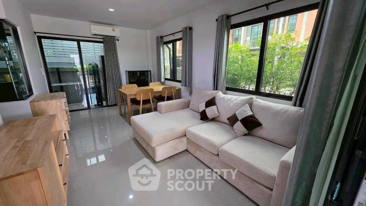 Spacious living room with modern furniture and large windows offering natural light.