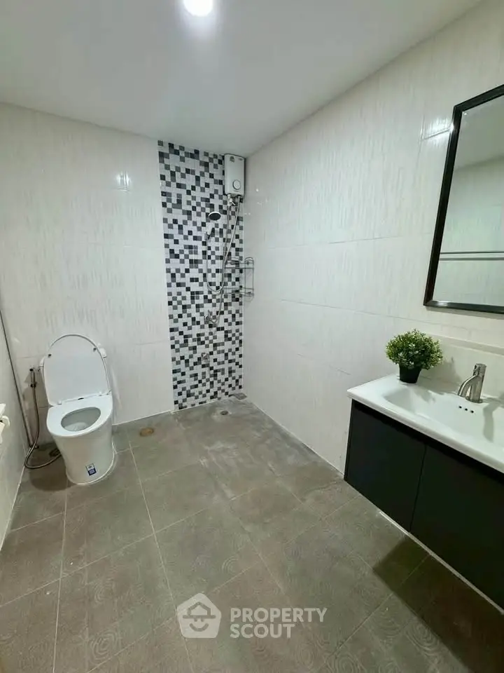 Modern bathroom with sleek design, featuring a stylish vanity and contemporary fixtures.
