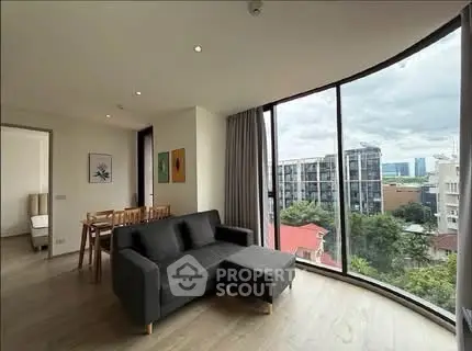 Spacious living room with panoramic city view and modern furnishings.