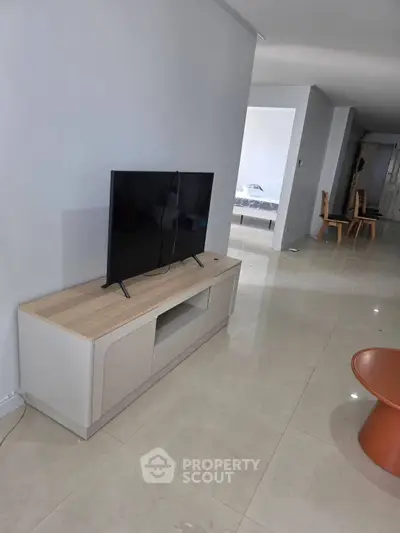 Modern living room with sleek TV stand and glossy tiled flooring