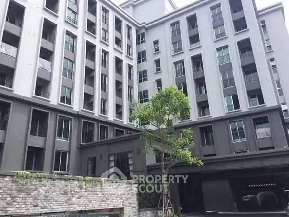 Modern multi-story residential building with sleek design and large windows.