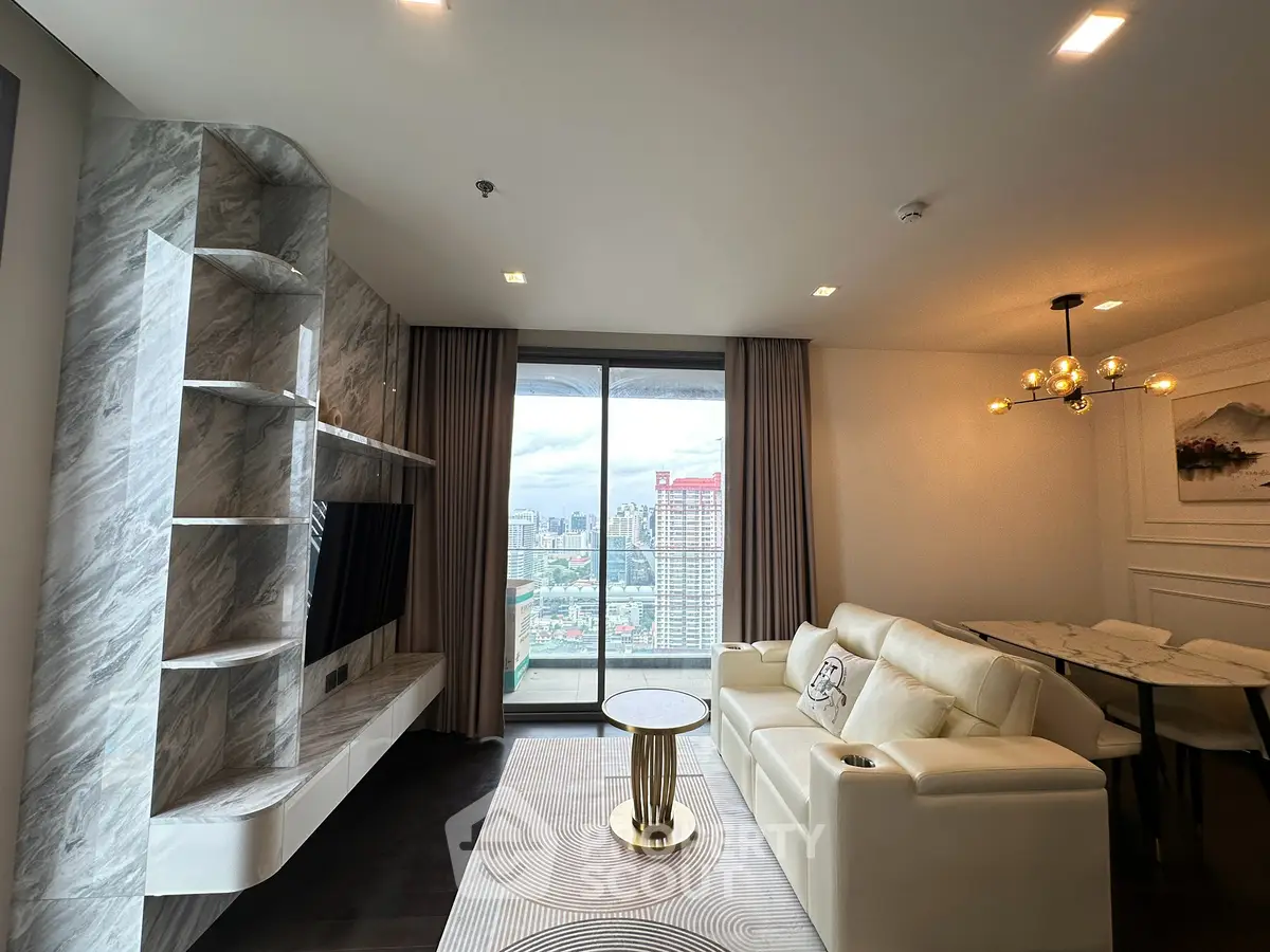 Luxurious living room with stunning city view, elegant marble accents, and modern furnishings in high-rise apartment.