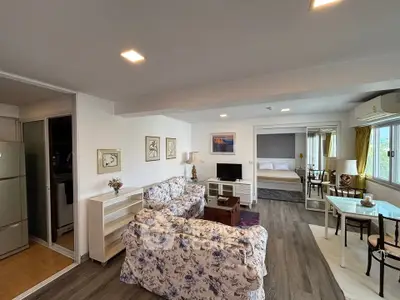 Spacious open-plan living room with floral sofas and modern decor