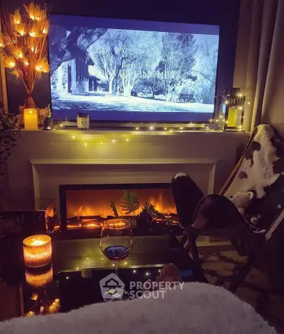 Cozy living room with fireplace, ambient lighting, and TV setup for a relaxing evening.