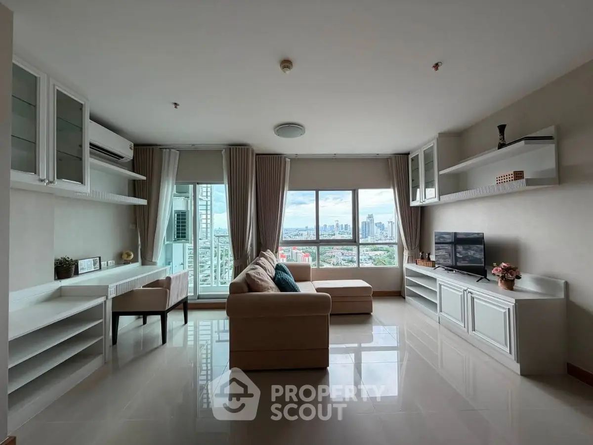 Spacious living room with city view, modern furniture, and large windows