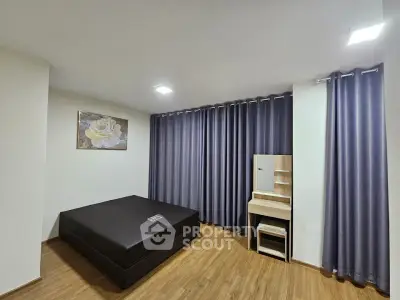 Spacious bedroom with modern decor and elegant curtains